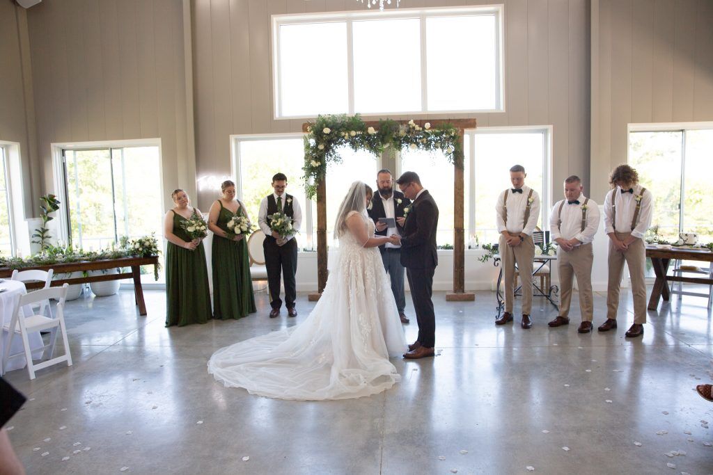 Beautiful wedding ceremony with big tall windows surrounding Bella Rosa a climate controlled venue near Tulsa Oklahoma