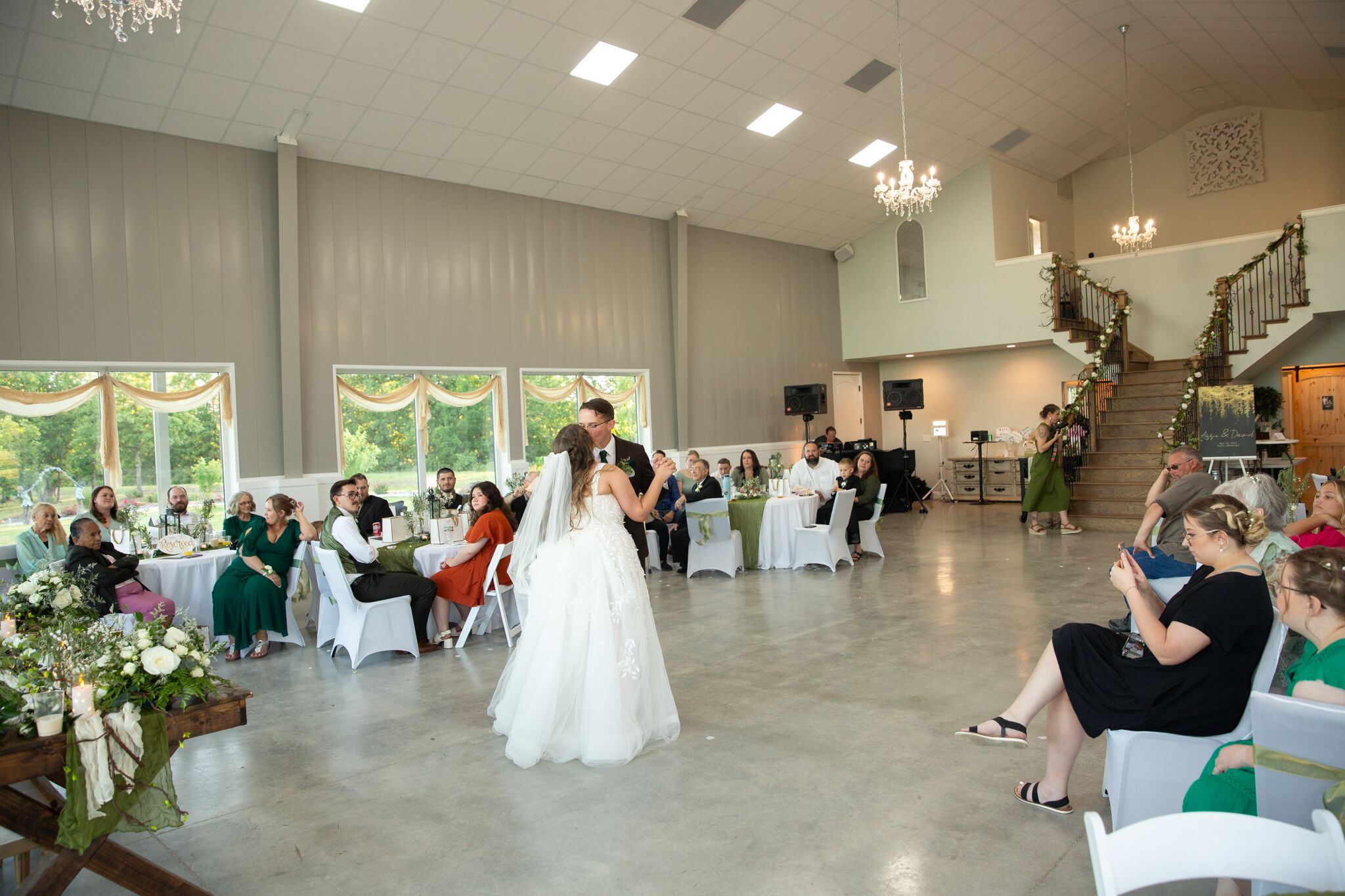 First dance as a couple at Tulsa reception after wedding ceremony with high white ceilings and beautiful staircase in background